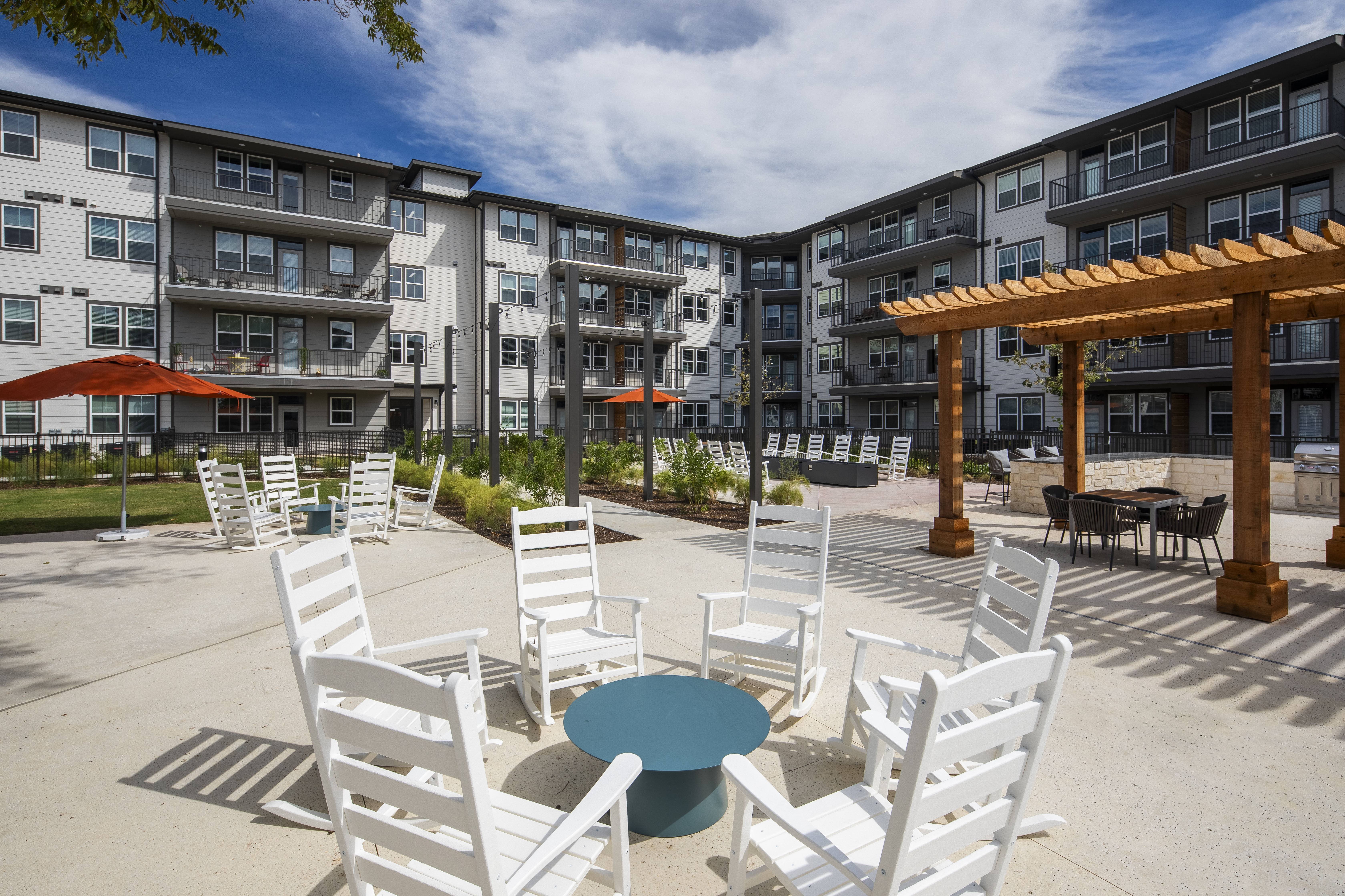 an outdoor patio with chairs and a table at a senior apartment community